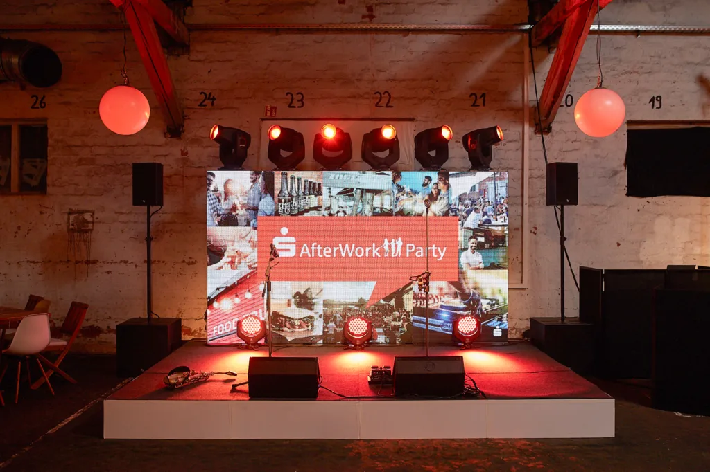 Eine kleine Bühne mit zwei Boxenund verschiedenen Lichtern auf einer Businessveranstaltung in der Halle 6