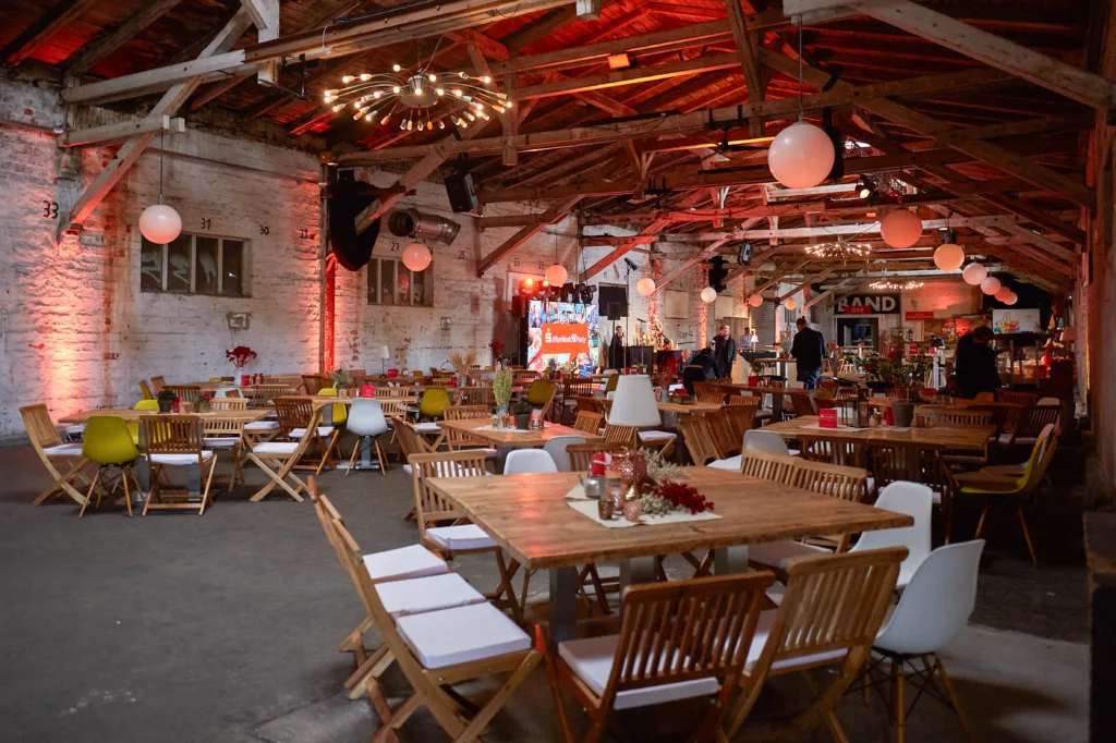 Eine Aufnahme der Halle 6 bei einer Weihnachtsfeier in Erfurt mit Bühne und Tischdekorationen